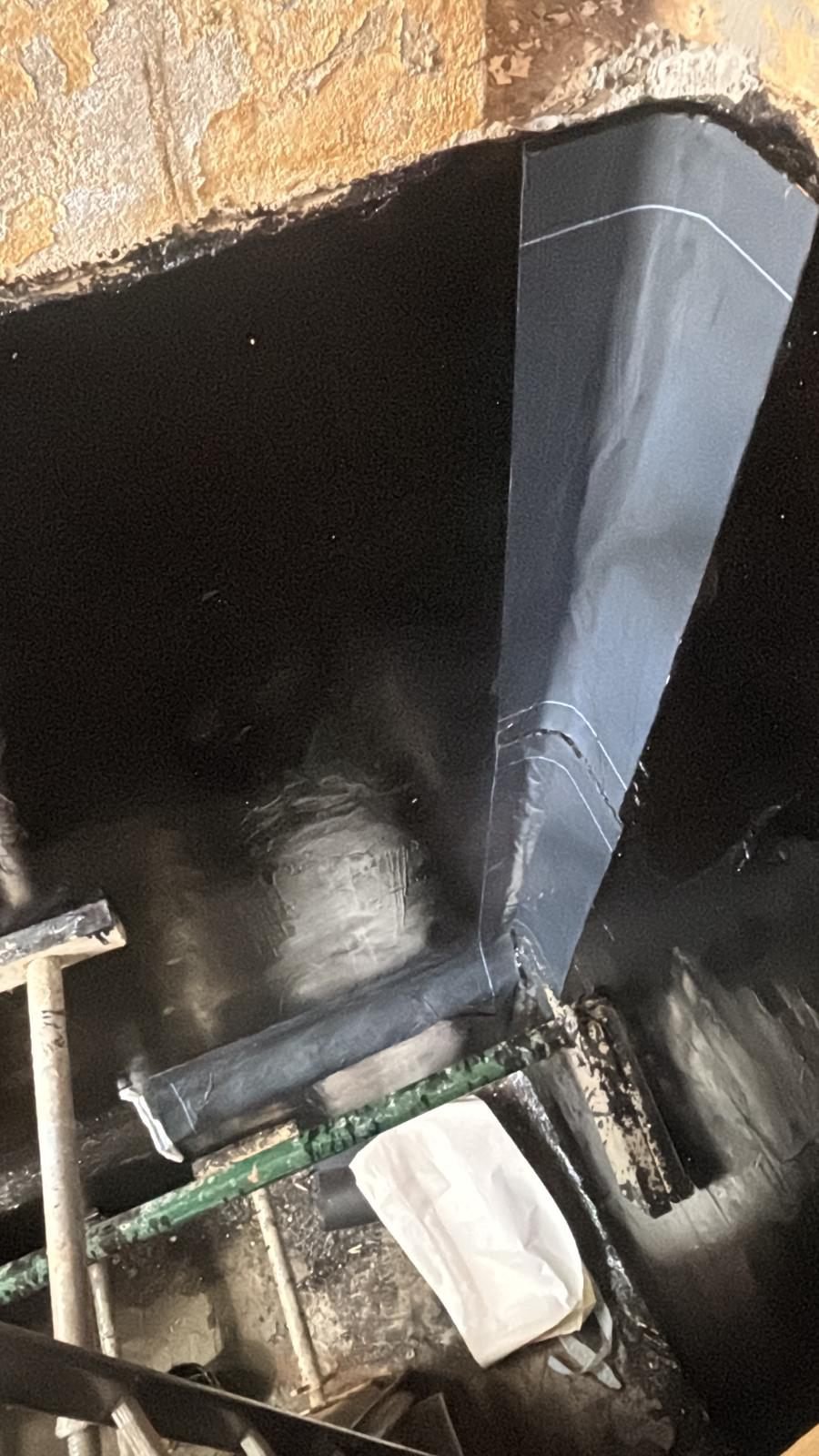 The protective release liner being peeled back from self-adhesive membrane where it is dressed into an internal corner
